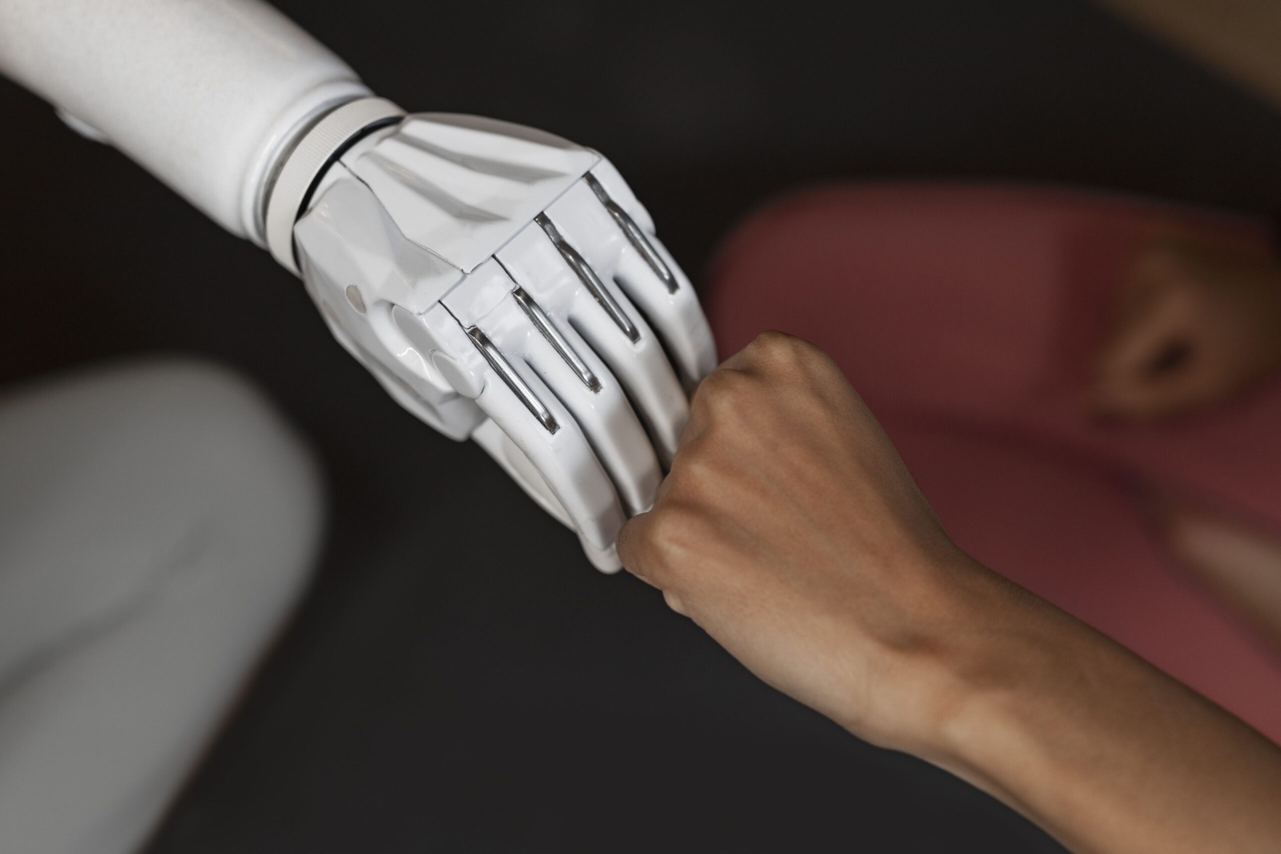 mão humana e mão robótica se cumprimentando