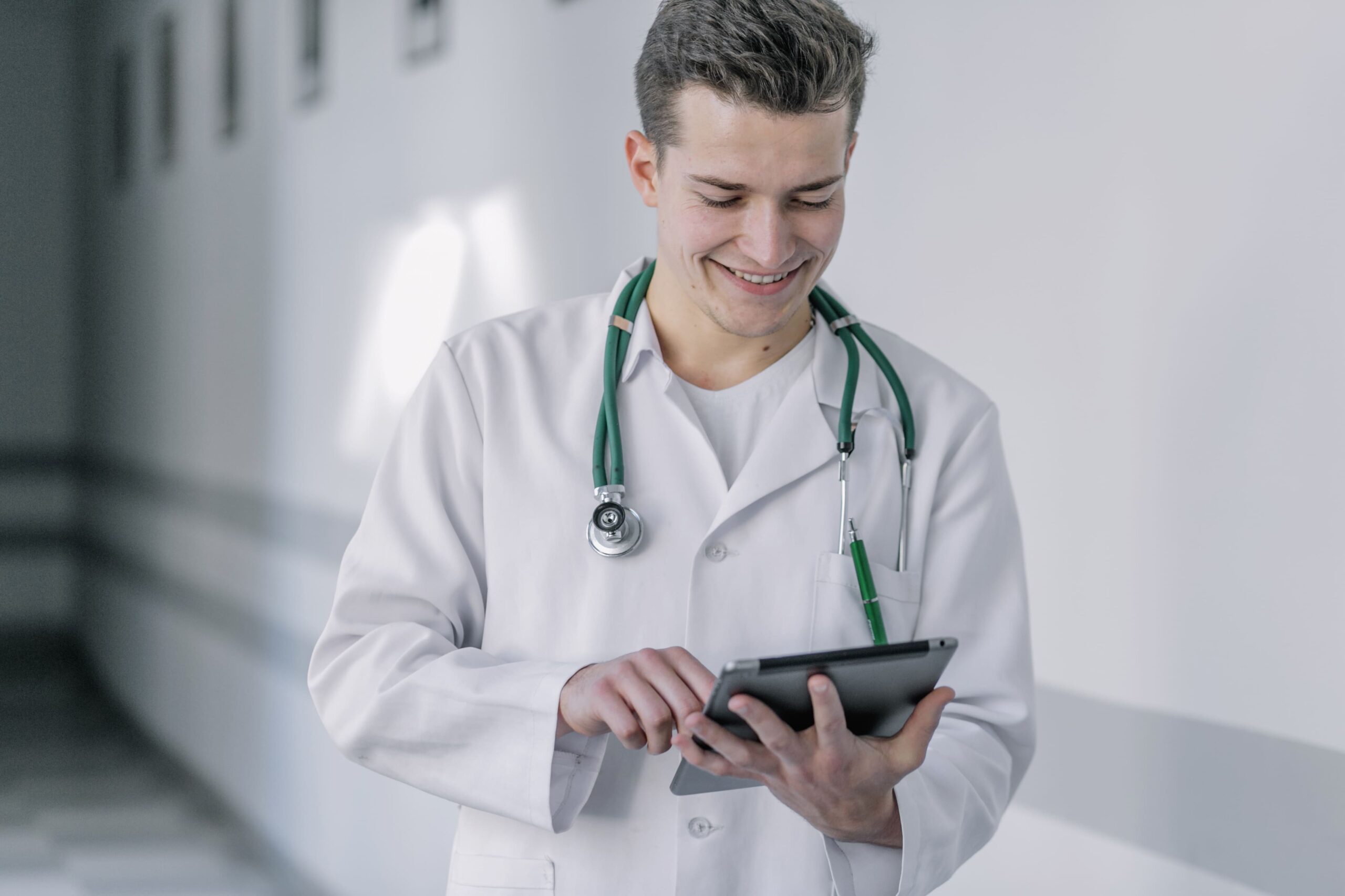 médico sorrindo segurando um tablet