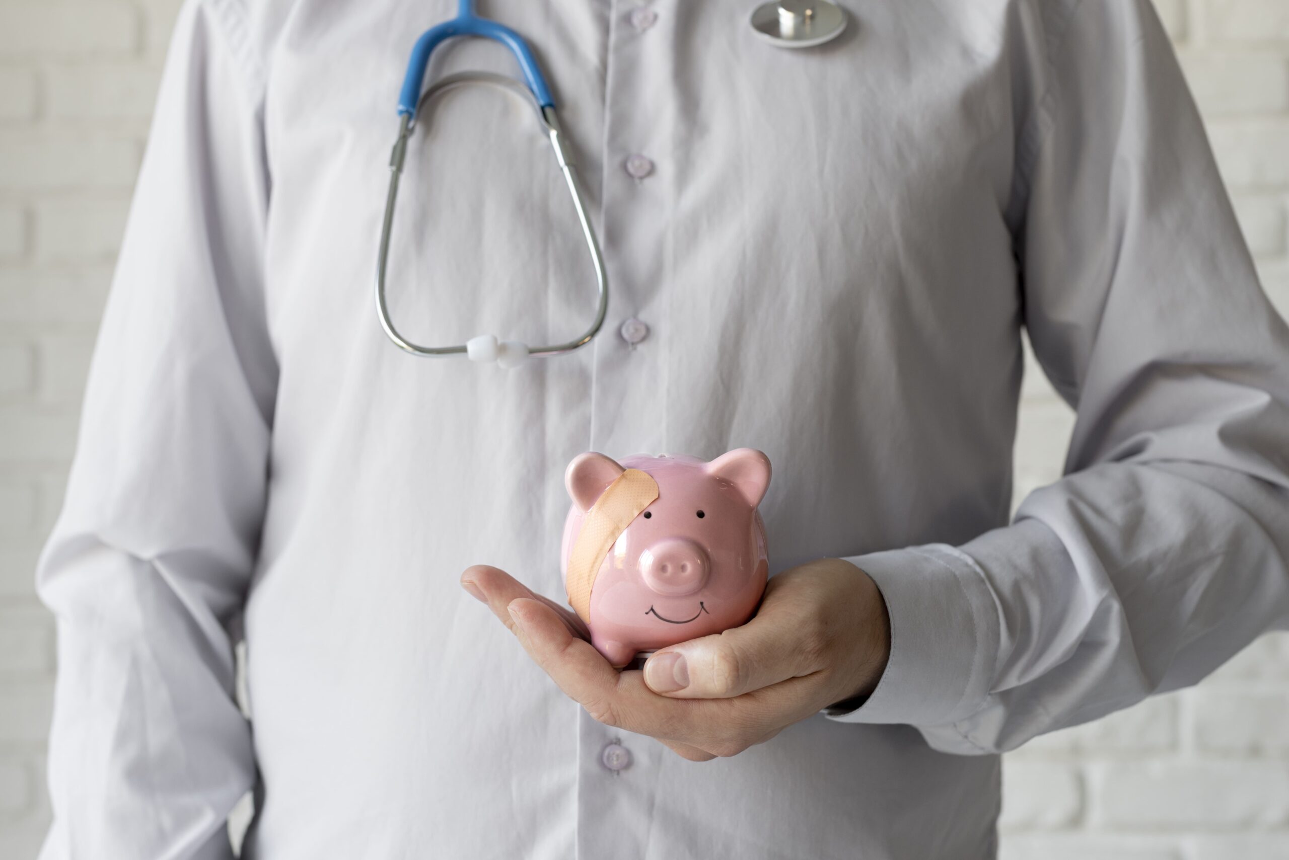 médico segurando cofrinho de porquinho