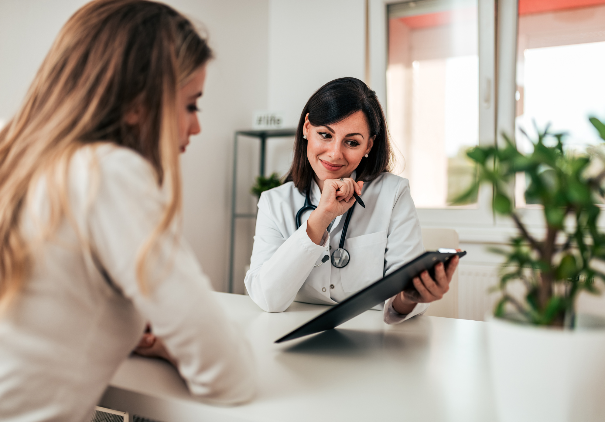 médica realizando uma revisão do pré-consulta com a paciente